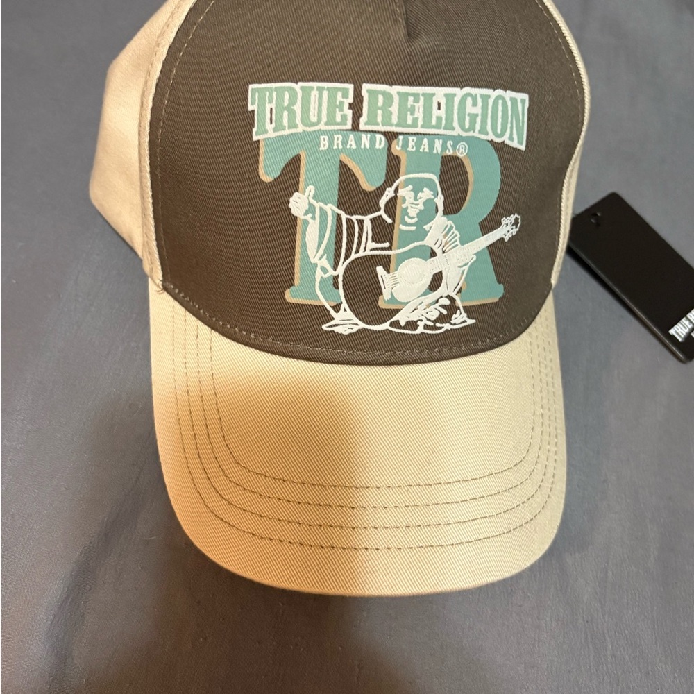 True Religion Buddha Ticket Trucker Hat in a brown and cream colorway
Adjustable